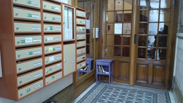 Eine Bibliothek mit mehreren Karteikastenladen, einer Holztür und einem gemusterten Boden.