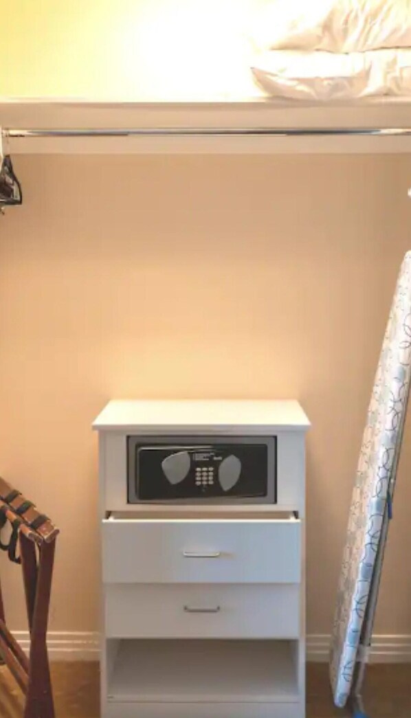A white bedside table with a radio, a drawer, and a hanging coat rack. - MGM Signature Tower 2 | 8th Floor 2-Suite | Strip View Balcony | No Resort Fee (LAS VEGAS)