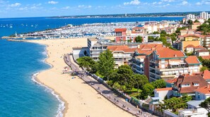 Une ville côtière dotée d’une plage, d’un port de plaisance et d’immeubles résidentiels.