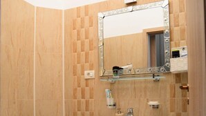 A bathroom with a toilet, sink, and mirror. - Barock Jimbolia (Jimbolia)