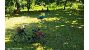 Una bicicleta con canasta y alforja estacionada en un césped.