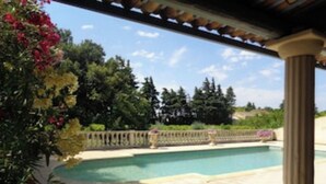 A pool area with a pergola, surrounded by lush greenery and trees. - Appartement de caractère dans un mas provençal (Jonquières)