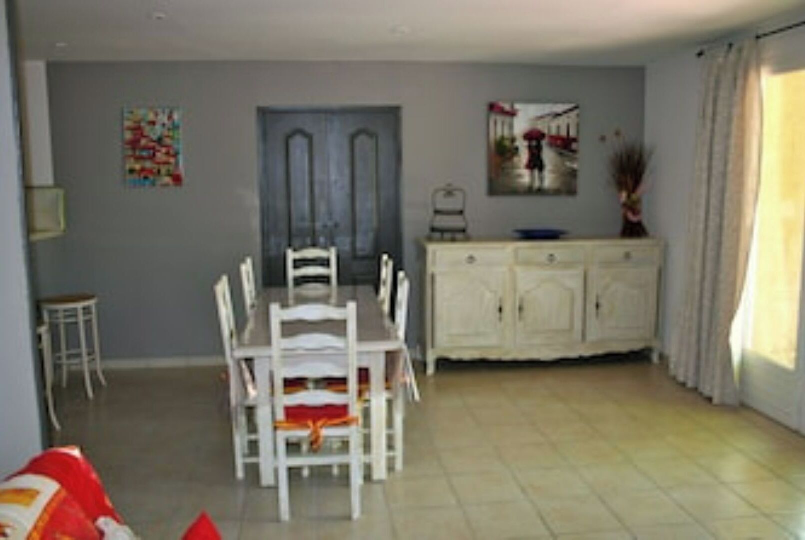 A dining area with a table and chairs, a cabinet, and a door.