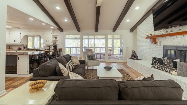 A spacious living area with a fireplace, a dining area, and a kitchen. - 4 Bedroom + 3.5 Bathroom Greers Ferry Lakefront Home in Heber Springs! (Heber Springs)