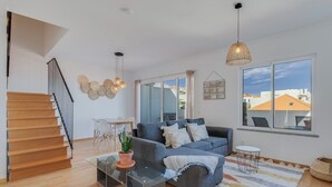 A modern living room with a sofa, coffee table, and a staircase. - Alta do Garajau I (Santa Cruz)