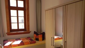 Een slaapkamer met een bed, een raam en een kledingkast.