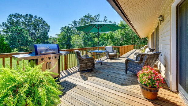 A wooden deck with a grill, wicker chairs, a table, and a potted plant. - Peaceful Millington Home ~ 13 Mi to Memphis! (Millington)