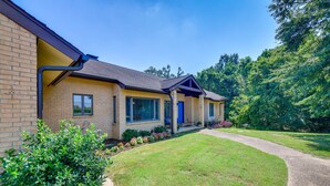 A two-story house with a brick exterior, a front porch, and a well-maintained lawn. - Peaceful Millington Home ~ 13 Mi to Memphis! (Millington)