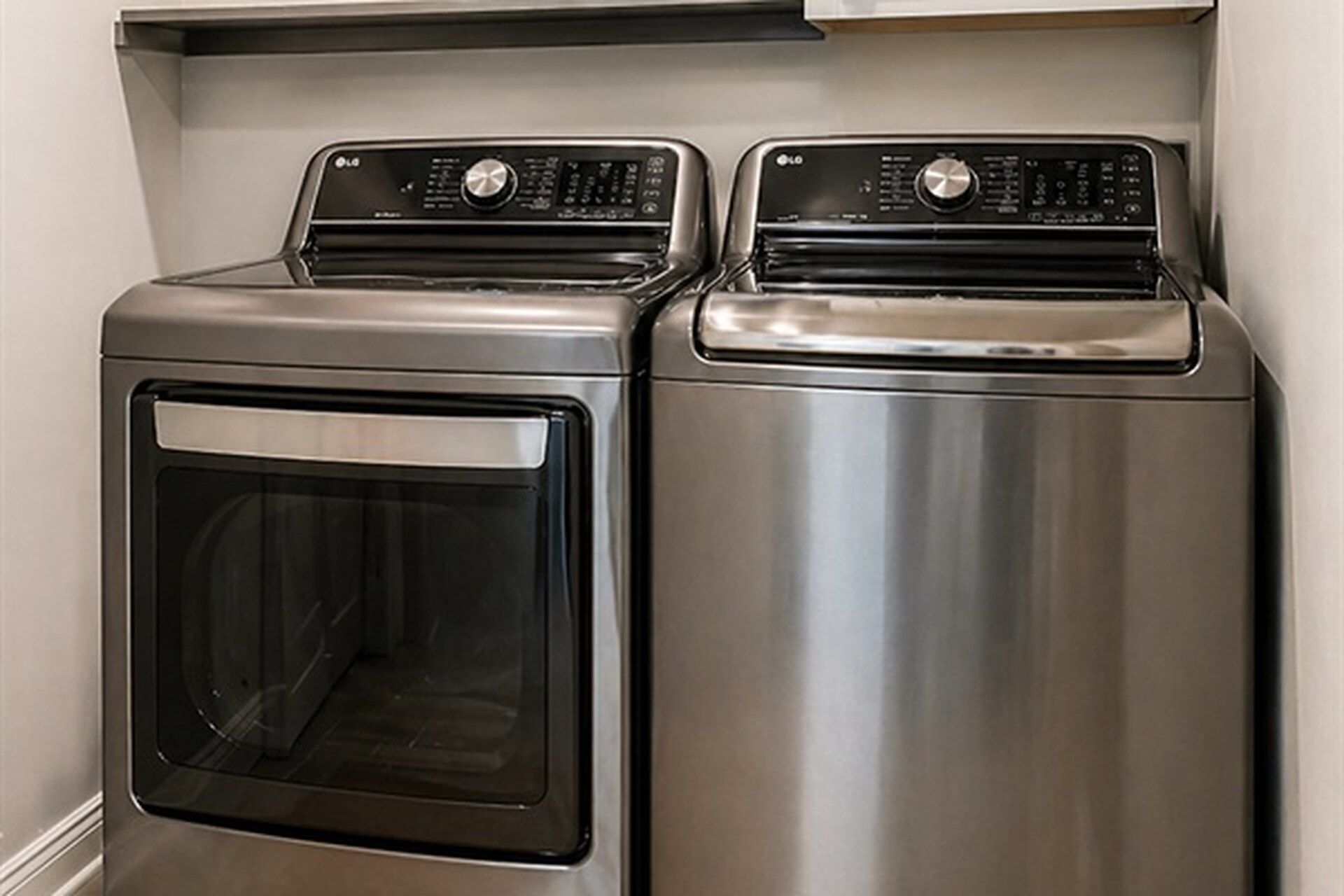Two stainless steel front-loading washers with control panels.