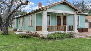 A single-story house with a porch, a chimney, and a number '206' on the front. - The Downtown Studio 3, Hot tub, Cowboy Pool! (Fredericksburg)
