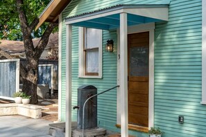 A house with a porch, a wooden door, and a small window. - The Downtown Studio 3, Hot tub, Cowboy Pool! (Fredericksburg)