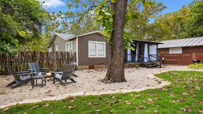 A two-story house with a patio area, a wooden deck, and a fenced yard.