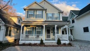 A two-story house with a front porch, a small front yard, and a driveway. - Beautiful home in Chautauqua community - linens, parking, washer Included (Lakeside Marblehead)