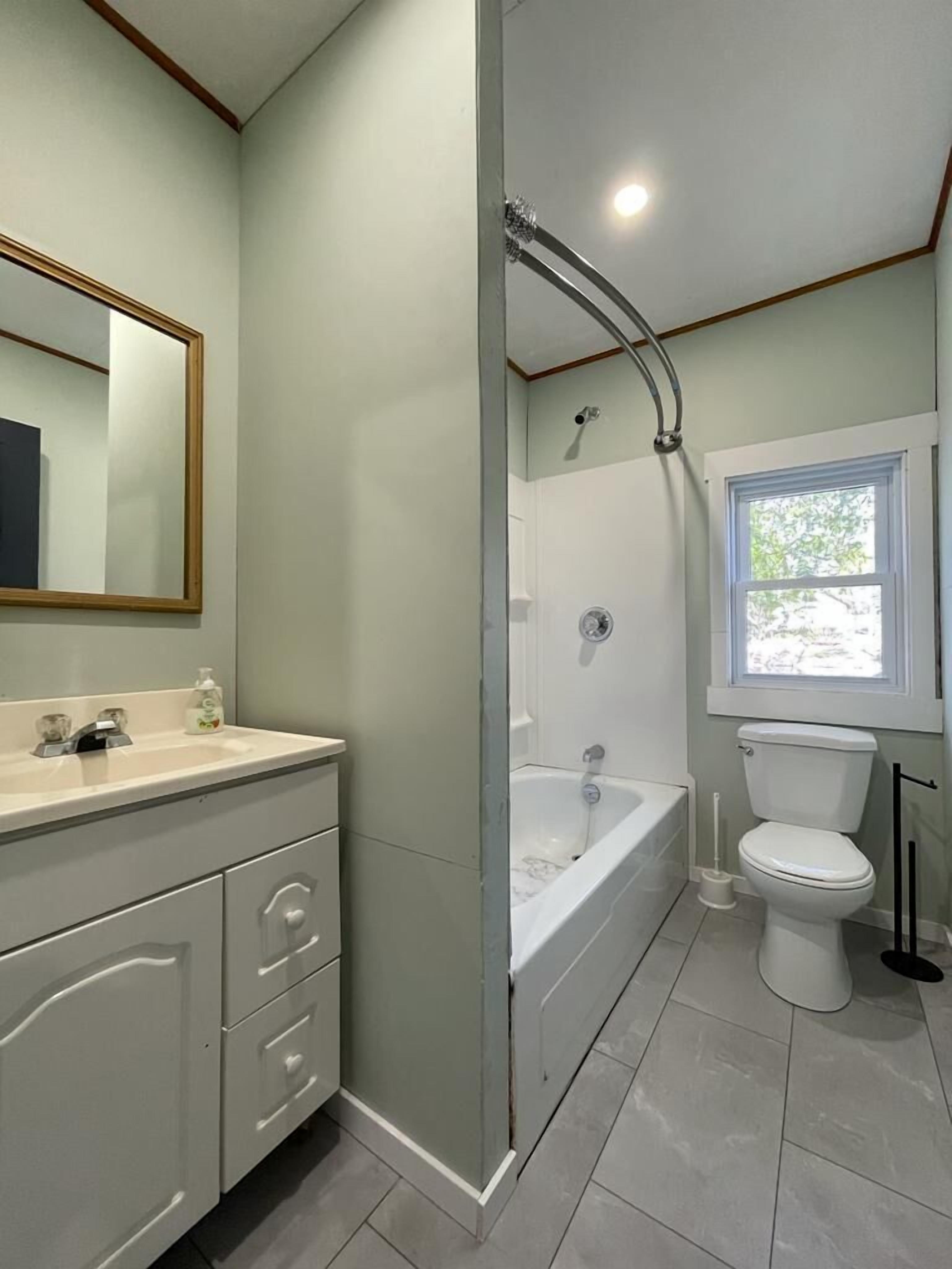 A bathroom with a shower, toilet, and vanity.