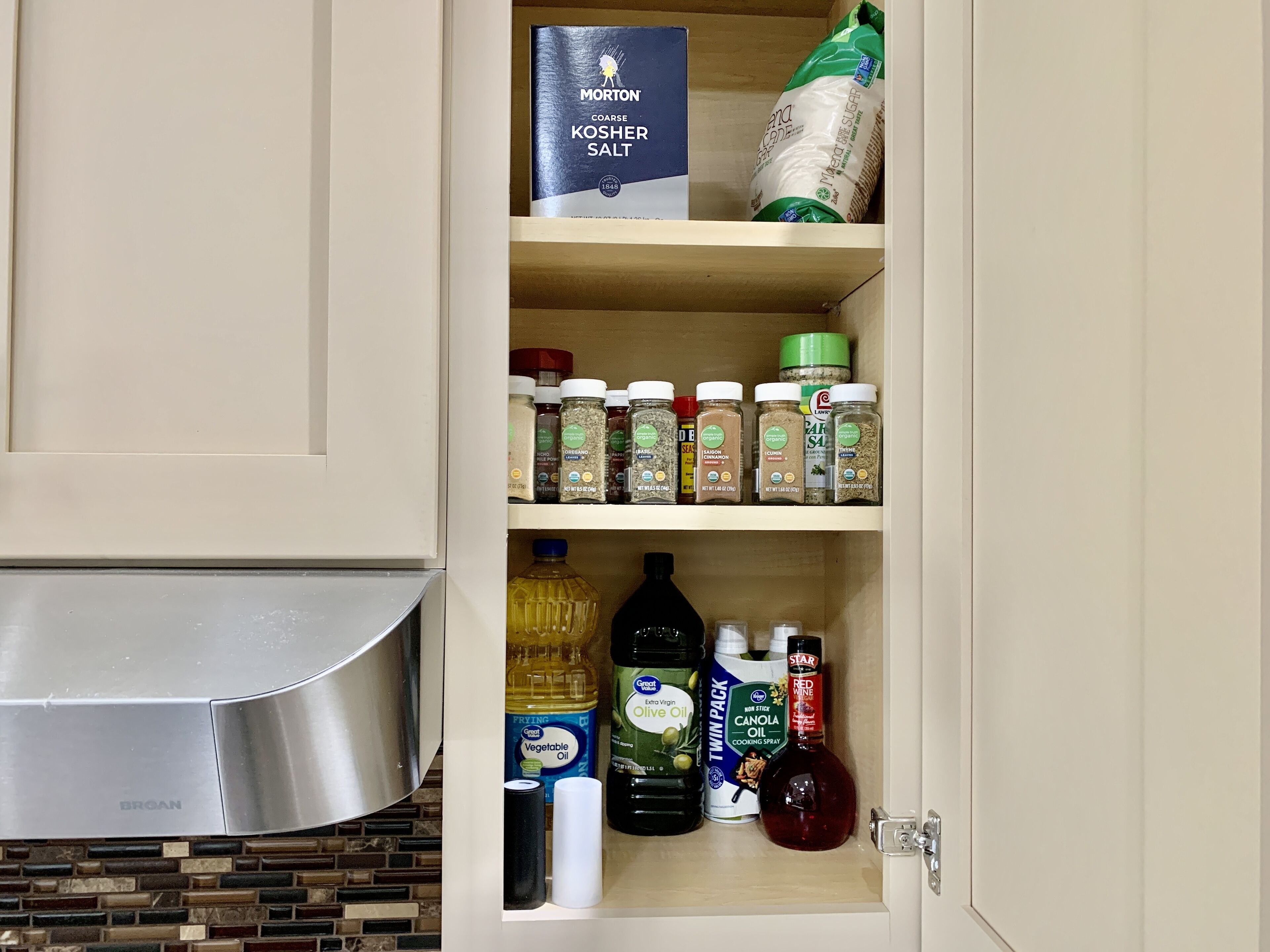 Un mueble de cocina con diferentes alimentos y aceites de cocina.