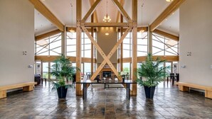 Eine großzügige Lobby mit hohen Decken, Holzbalken und großen Fenstern.