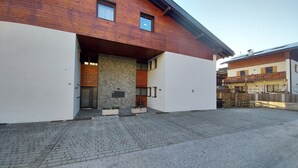 A modern building with a stone facade, a wooden upper level, and a paved entrance area. - Fié allo Sciliar (Alpe di Siusi Val Gardena) (Fiè allo Sciliar)