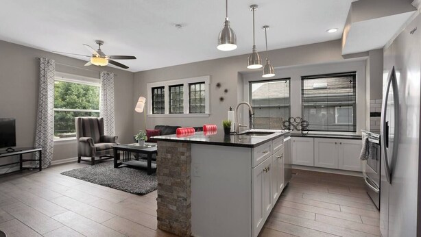 A modern kitchen with a central island, white cabinetry, and a built-in refrigerator. - Spacious 5 Bedroom Duplex In Kansas City! 65/66 (Kansas City)