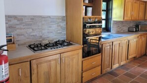Eine Küche mit Holzausstattung, einem Gasherd, einem Backofen und einem Fenster.