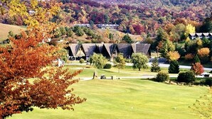 A golf course with a clubhouse and surrounding autumn foliage. - Sky's The Limit -Mountain view, golf course, waterfalls, game room. Sleeps 14 (Sky Valley)