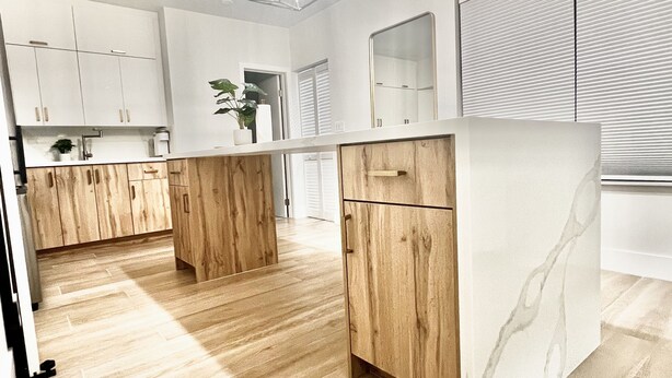 A modern kitchen with wooden cabinets, a marble countertop, and a geometric pendant light. - Charming, Cozy in the heart of Miami~Near Airport, Brickell, US1 and the Gables  (Miami)