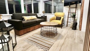 A modern living room with a sofa, armchair, coffee table, and a chandelier. - Charming, Cozy in the heart of Miami~Near Airport, Brickell, US1 and the Gables  (Miami)