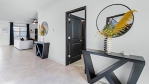 Un salon moderne avec un canapé, une console et un miroir décoratif.