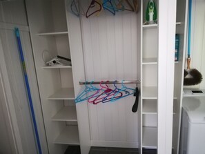 A white closet with shelves and a rod for hanging clothes.