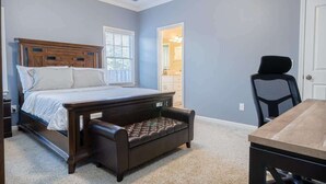 Un dormitorio con cama, escritorio y silla.