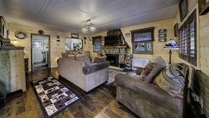 A cozy living room with a fireplace, wooden walls, and a television. - Rustic Cozy Cabin at the base of Greenhorn Mountain. (Rye)