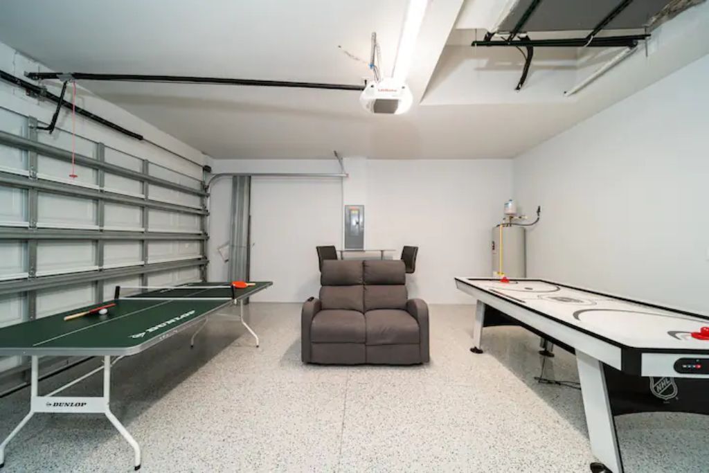 A room with a pool table, a snooker table, and a reclining chair.