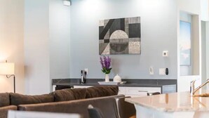 Un salon moderne avec un canapé marron, une table basse blanche et un vase décoratif orné de fleurs violettes.