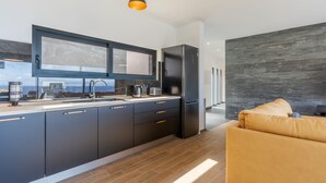 Una cucina moderna con mobili scuri, un'ampia finestra e un forno a incasso.