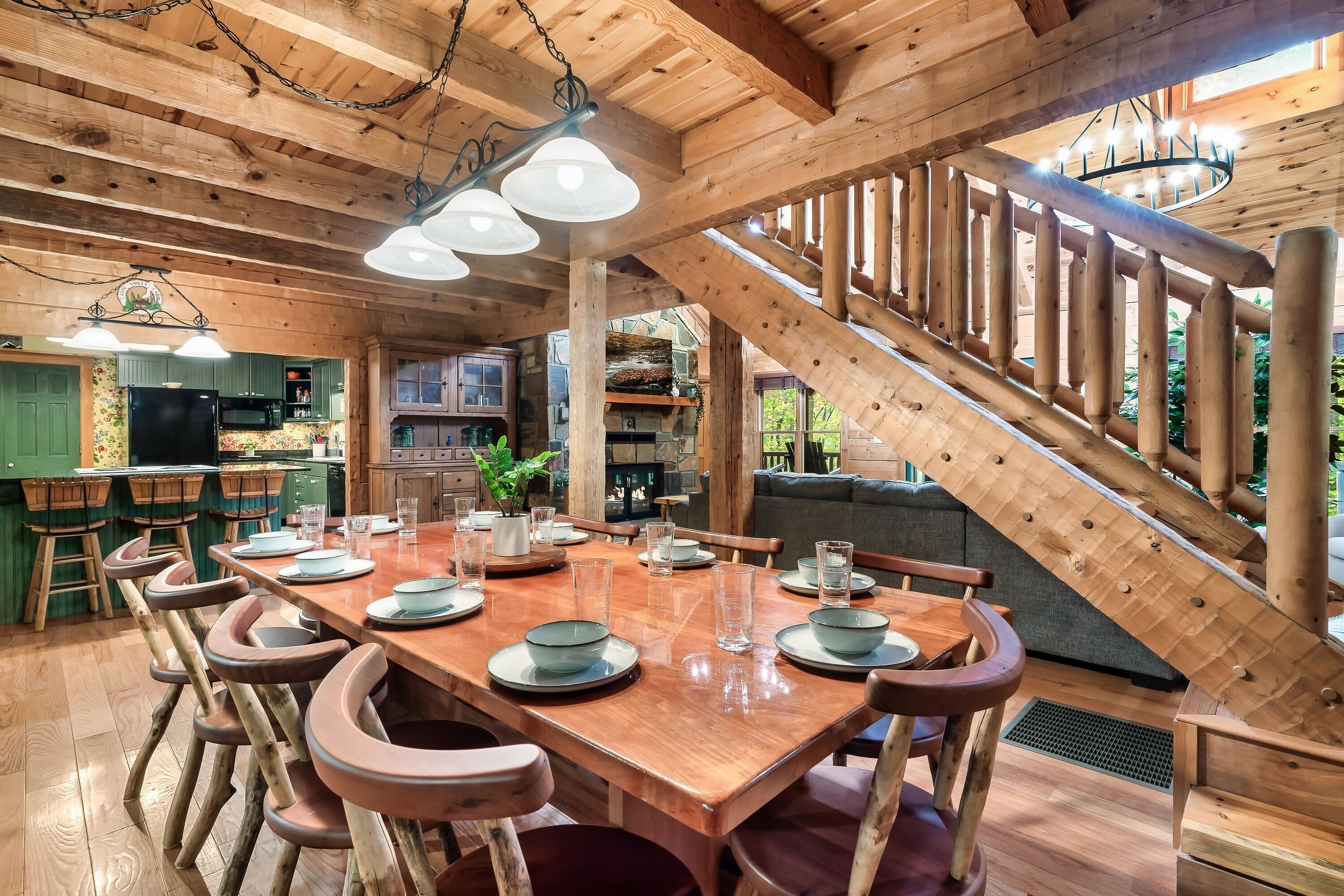 Un intérieur en bois comprenant un espace repas avec une longue table, des chaises et un escalier.