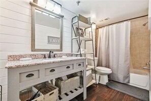 Een bad/douchecombinatie, een haardroger, handdoeken
