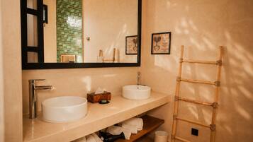 Un baño con dos lavamanos, un espejo y una escalera de madera.