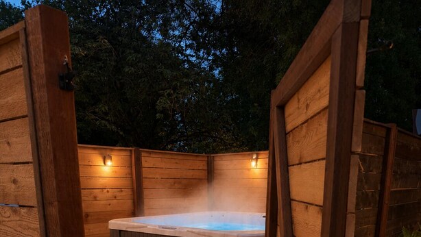 A wooden hot tub with steps and towels, surrounded by wooden walls and a concrete floor. - Quiet Glamping Barn on a Working Farm with Fire Pit and Open Views (Lynden)