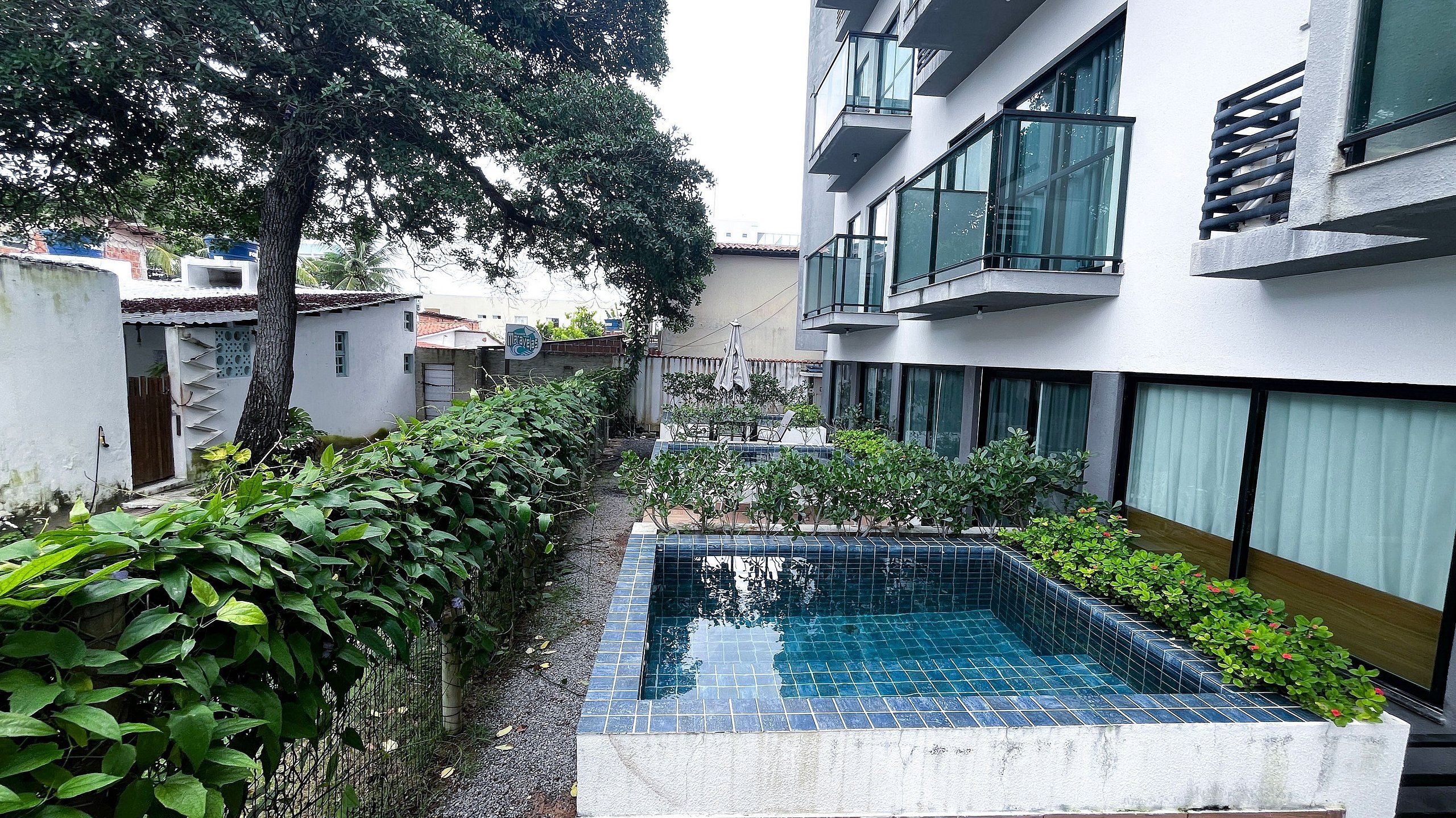 Ein Innenhof mit Swimmingpool, umgeben von Grünflächen und modernen Gebäuden.