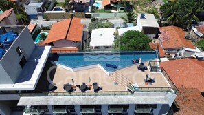 A rooftop pool with lounge chairs and a glass balustrade. - Lindos Flats - Maraca Beach Residence II (Ipojuca)