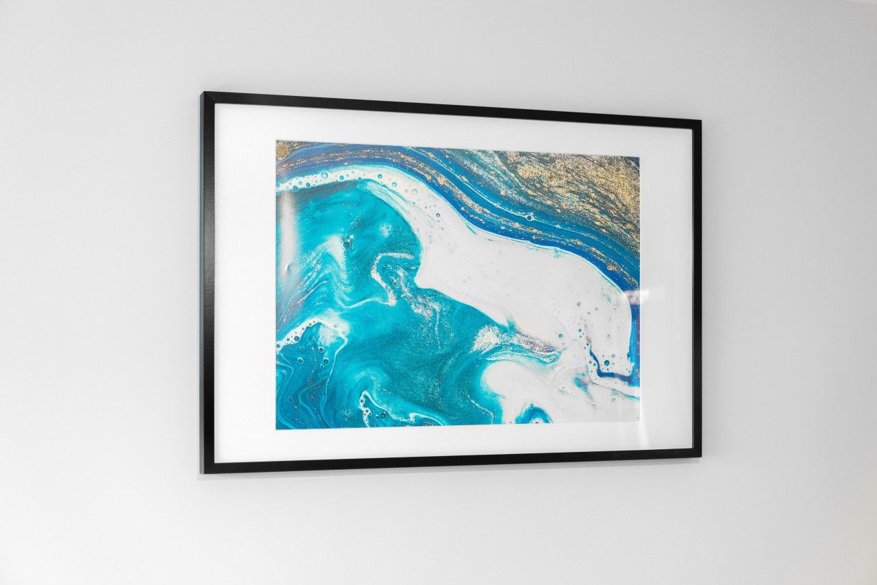 Uma pintura abstrata emoldurada, com cores azul e branco.