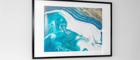 Uma pintura abstrata emoldurada, com cores azul e branco.