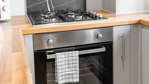 A kitchen with a gas stove, oven, and wooden countertop. - Brand New - Two Bed - Parking - Stourbridge (West Midlands)