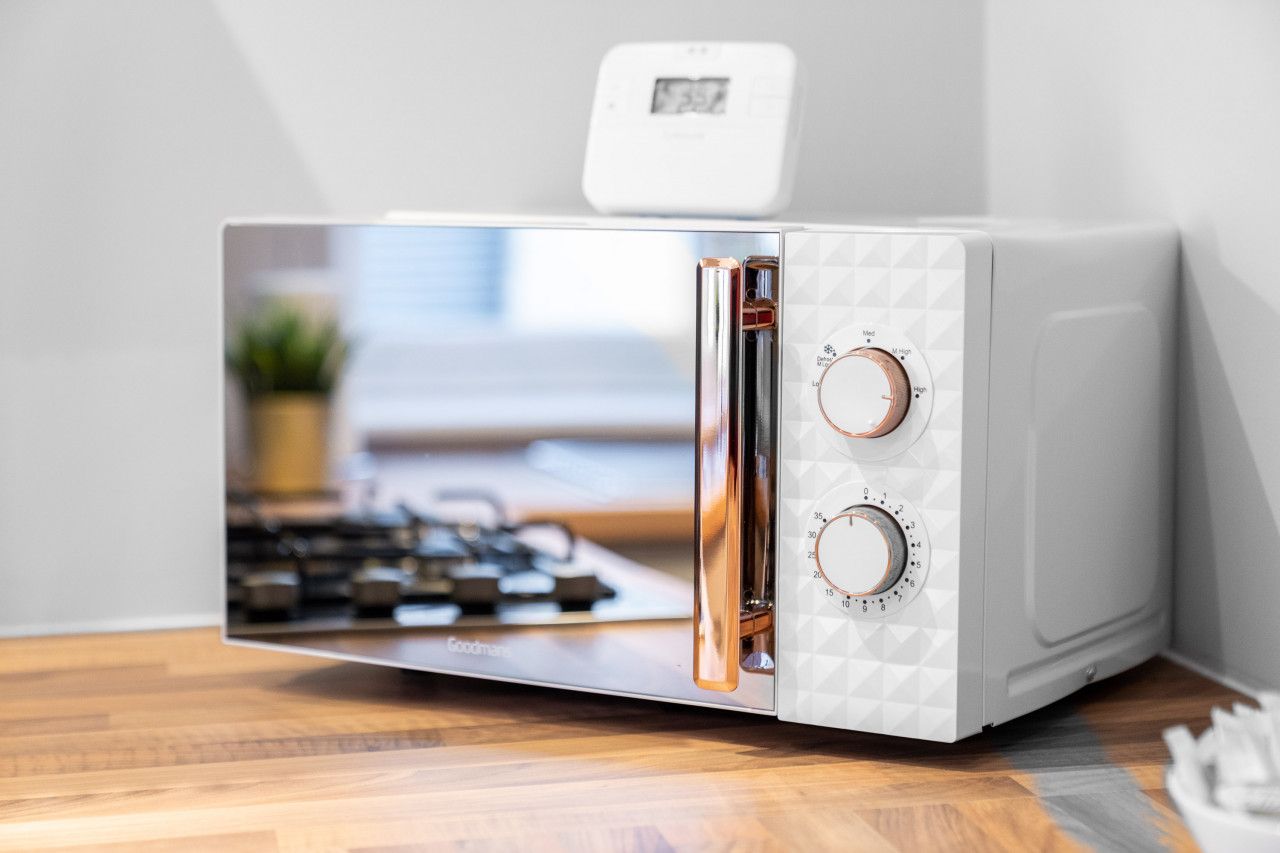 A compact microwave with a digital display and two control knobs.