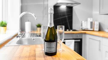 Eine Flasche Prosecco auf einer Küchenarbeitsplatte mit einem Glas.