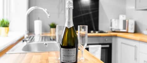 Una botella de vino Prosecco sobre una encimera de cocina con una copa.