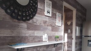 A modern kitchen with wooden paneling, a white countertop, and a refrigerator. - Cozy & Modern (Willemstad)