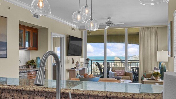 A modern kitchen with granite countertops, a stainless steel faucet, and pendant lighting. - MVG 1416 Ocean View Penthouse (North Myrtle Beach)