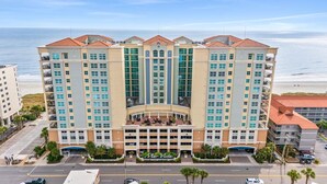 A multi-story hotel with a central courtyard, large windows, and a beach view. - MVG 1416 Ocean View Penthouse (North Myrtle Beach)