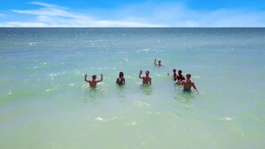 A group of people in a clear, shallow sea.
