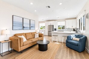 A modern living room with a sofa, coffee table, and a blue armchair.